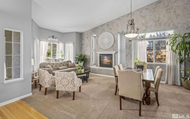 dining area with a glass covered fireplace, baseboards, and wood finished floors