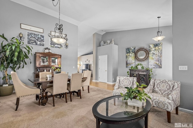 dining area featuring baseboards and high vaulted ceiling