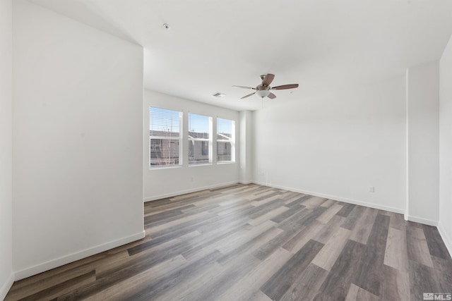 empty room with a ceiling fan, baseboards, and wood finished floors