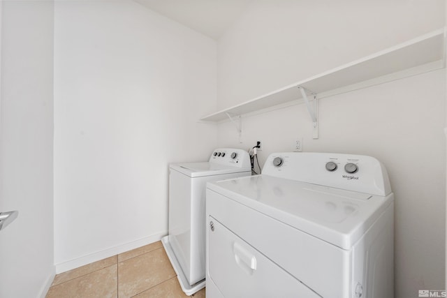 laundry room featuring laundry area, baseboards, washing machine and clothes dryer, and light tile patterned floors