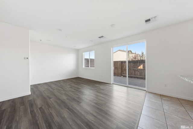 unfurnished room featuring visible vents, baseboards, and wood finished floors