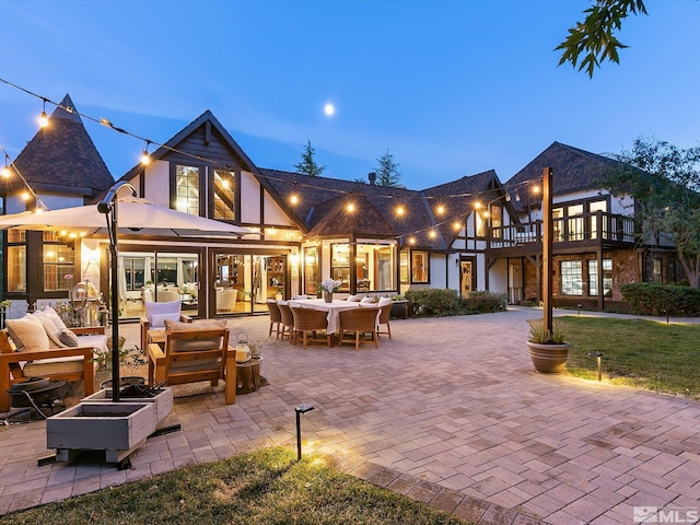 rear view of property featuring a patio and an outdoor living space