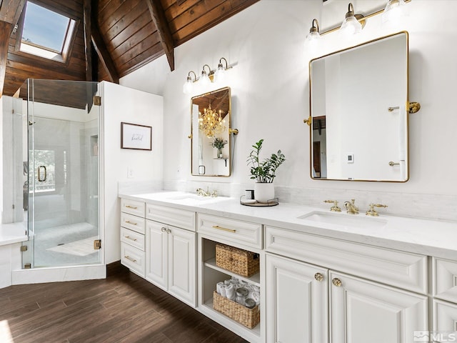 bathroom with lofted ceiling with skylight, a stall shower, and a sink