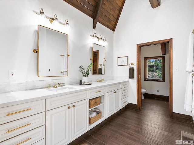 bathroom with double vanity, beam ceiling, a sink, and wood ceiling