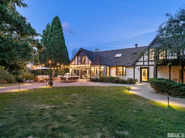 view of front of home featuring a patio, a front lawn, outdoor lounge area, and stucco siding