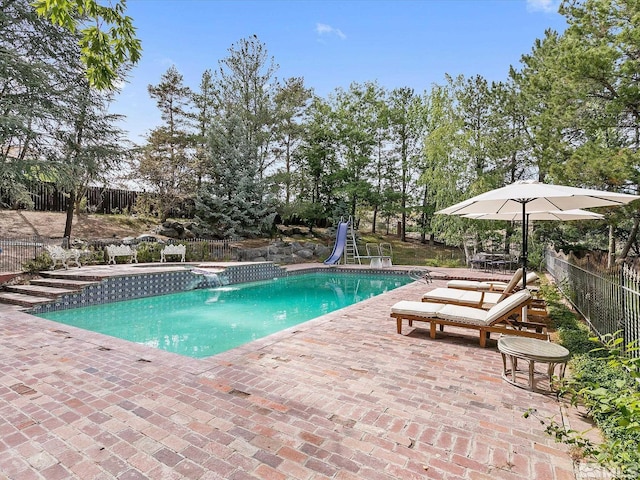 view of swimming pool with a patio area, a fenced in pool, fence, and a water slide