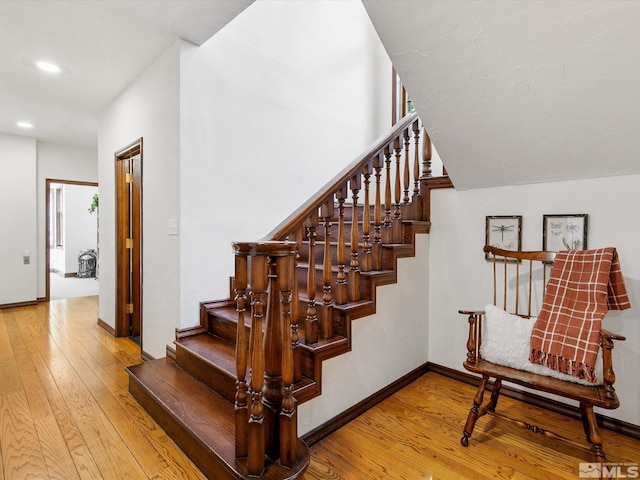 staircase featuring recessed lighting, wood-type flooring, and baseboards