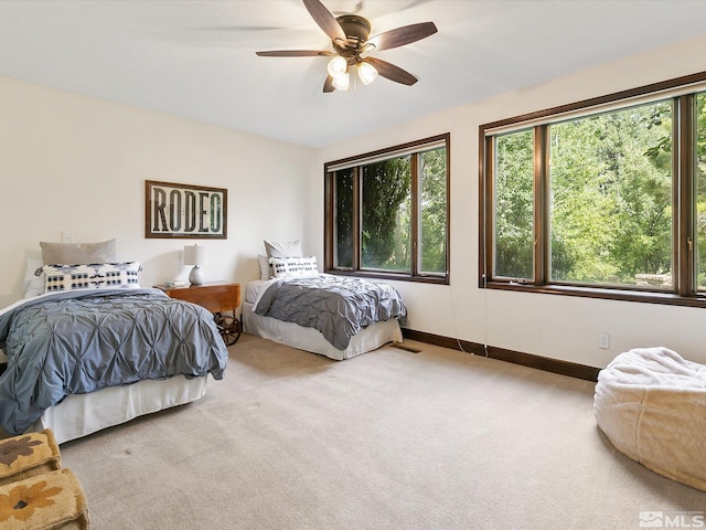 carpeted bedroom featuring ceiling fan and baseboards