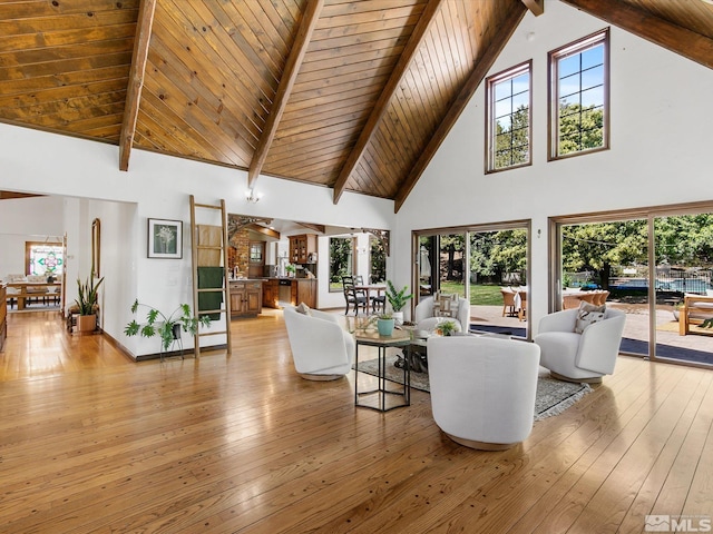 living room featuring high vaulted ceiling, wooden ceiling, beam ceiling, and light wood-style floors