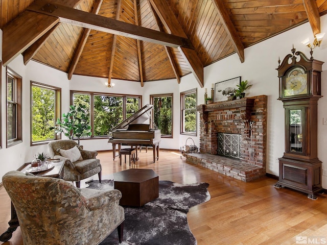 living area with beamed ceiling, a fireplace, wood finished floors, and wooden ceiling