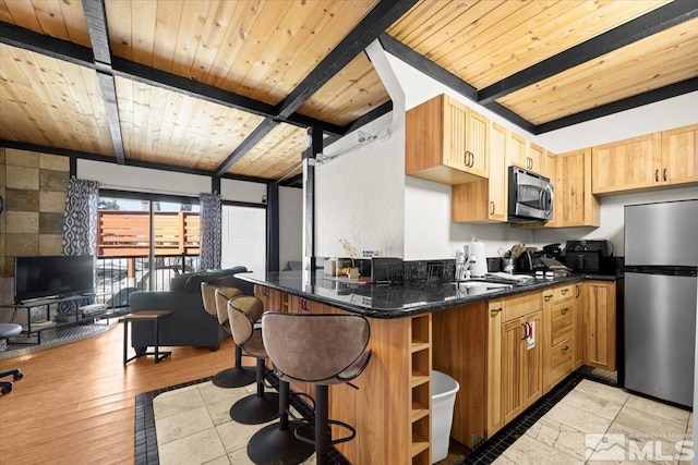 kitchen with wood ceiling, light wood-style flooring, appliances with stainless steel finishes, a kitchen bar, and beam ceiling