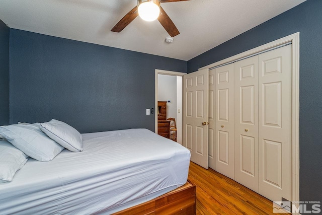 bedroom featuring a closet, a ceiling fan, and wood finished floors