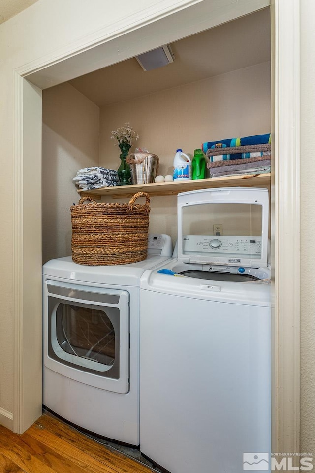 laundry room featuring wood finished floors and separate washer and dryer