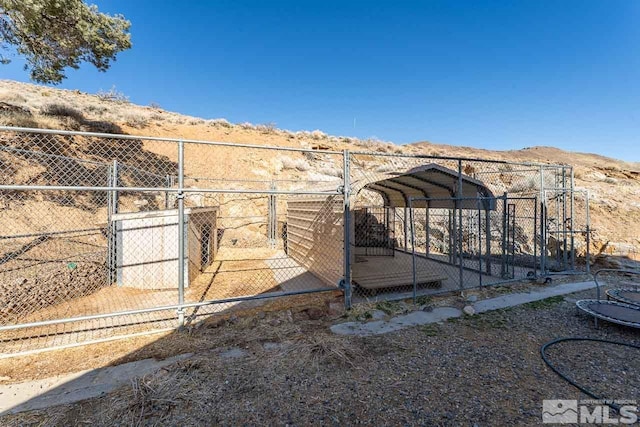 view of yard with fence, a mountain view, and a detached carport