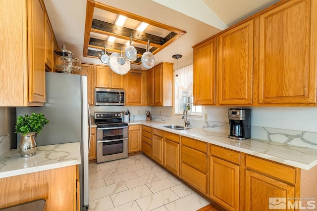 kitchen featuring marble finish floor, appliances with stainless steel finishes, a sink, and brown cabinets