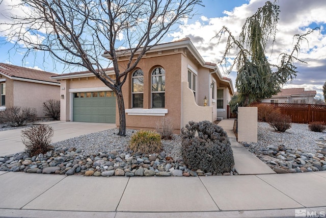 view of front facade with a garage, fence, concrete driveway, and stucco siding