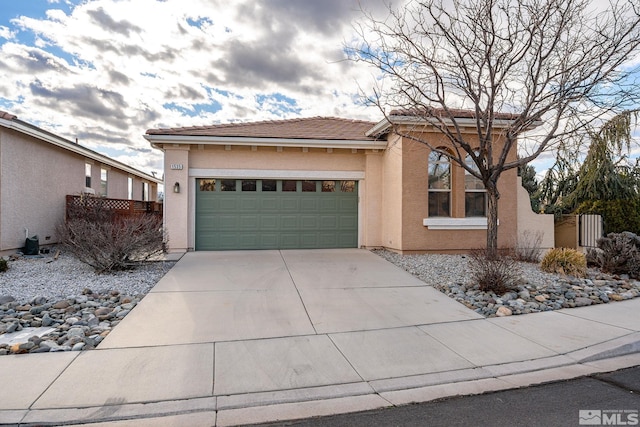 view of front of home with an attached garage, fence, concrete driveway, a tiled roof, and stucco siding