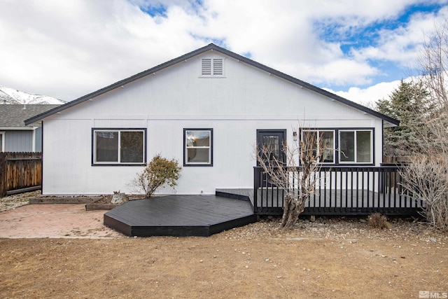 back of house with a deck and fence