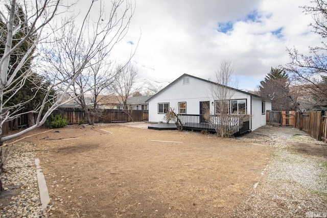 back of house with a fenced backyard and a deck