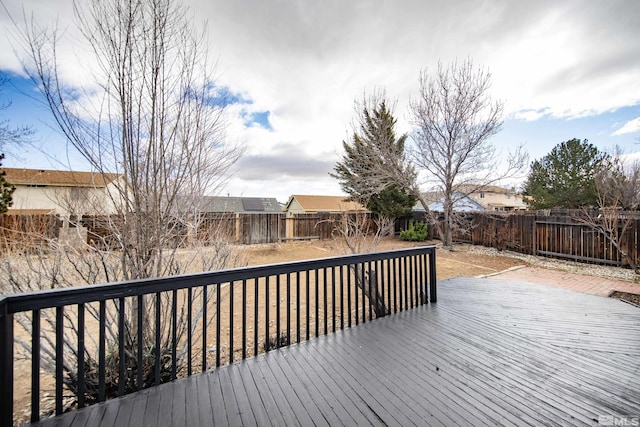 wooden deck with a fenced backyard