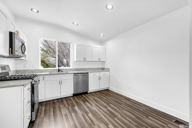 kitchen with appliances with stainless steel finishes, dark wood-type flooring, white cabinetry, and recessed lighting