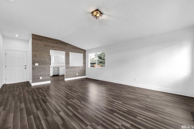 unfurnished living room with lofted ceiling, dark wood-style floors, wooden walls, and baseboards