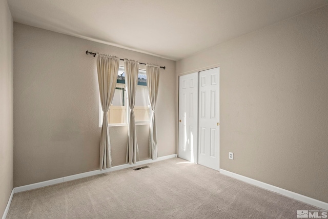 carpeted empty room with visible vents and baseboards