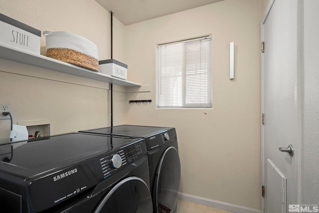 clothes washing area with washing machine and dryer, laundry area, and baseboards