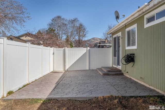 view of patio / terrace featuring a fenced backyard and a mountain view