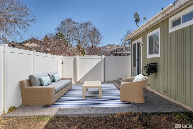 view of patio / terrace featuring outdoor lounge area, a mountain view, and a fenced backyard