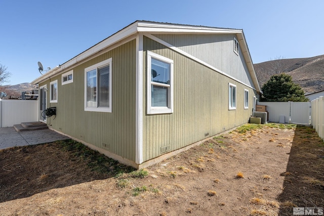 view of side of property with a patio, entry steps, crawl space, cooling unit, and a fenced backyard