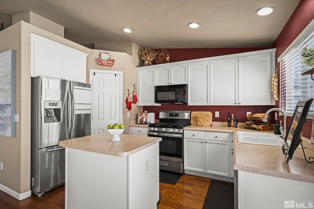 kitchen with stainless steel appliances, dark wood-type flooring, a sink, and white cabinets