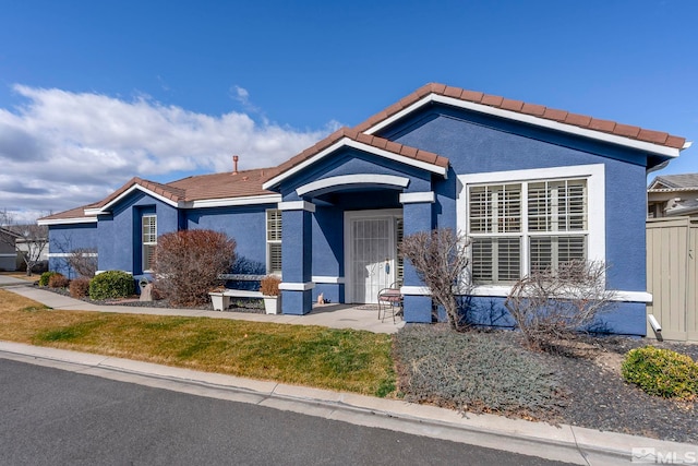 view of front of house with a tiled roof and stucco siding