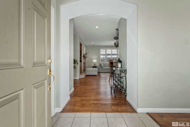 entryway featuring arched walkways, recessed lighting, baseboards, and light tile patterned floors