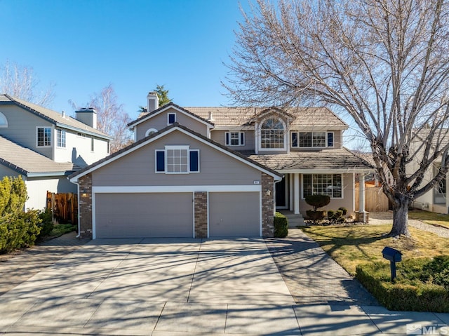 traditional home with fence, driveway, and an attached garage