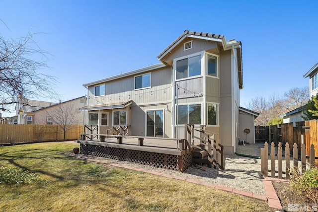 rear view of property with a fenced backyard, a wooden deck, and a yard