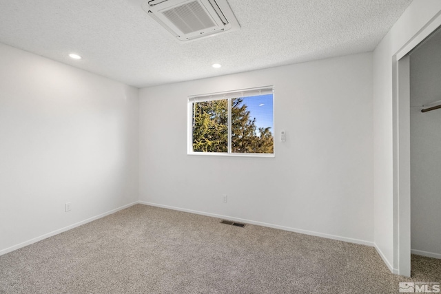 unfurnished bedroom featuring carpet floors, visible vents, a textured ceiling, and recessed lighting