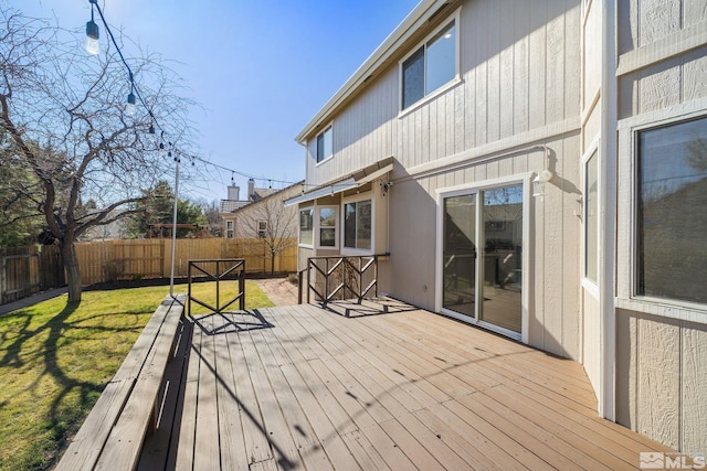 wooden deck featuring a fenced backyard and a lawn