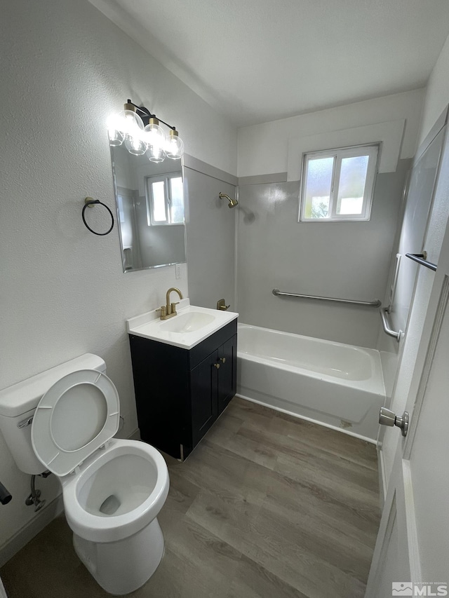 bathroom featuring toilet, vanity, wood finished floors, and shower / bathing tub combination