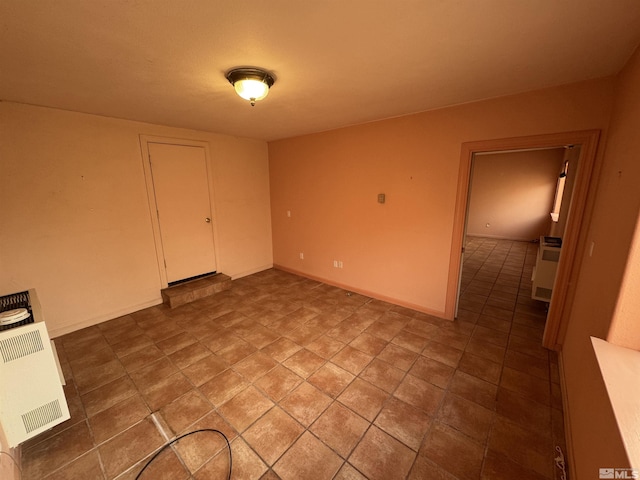 unfurnished bedroom featuring baseboards and heating unit