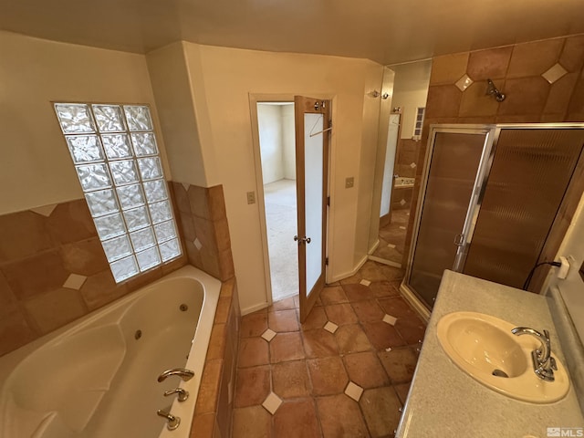 bathroom with a stall shower, tile patterned flooring, a jetted tub, and vanity