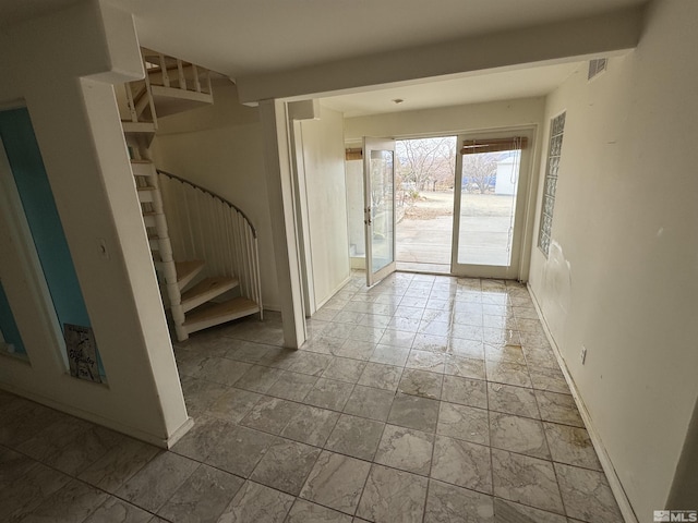 entrance foyer featuring stairway, visible vents, and baseboards