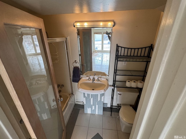 bathroom with toilet, tile patterned flooring, and bathing tub / shower combination