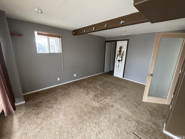 unfurnished room with carpet flooring and baseboards