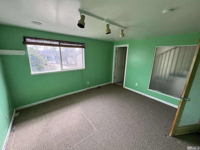 spare room with carpet and baseboards