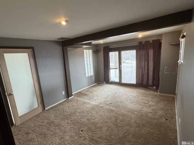 spare room with carpet, visible vents, and baseboards