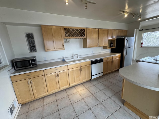 kitchen featuring light tile patterned floors, stainless steel appliances, visible vents, light brown cabinets, and a sink