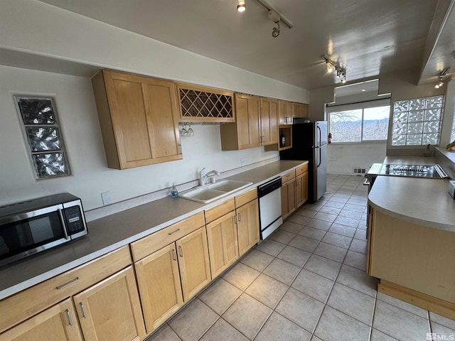 kitchen with appliances with stainless steel finishes, a sink, light brown cabinets, track lighting, and light tile patterned flooring