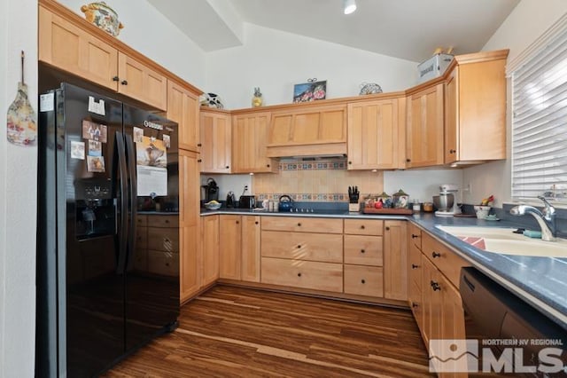 kitchen with light brown cabinets, black refrigerator with ice dispenser, vaulted ceiling, and a sink