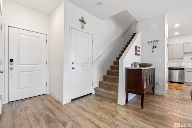 foyer featuring light wood finished floors, stairway, recessed lighting, and baseboards